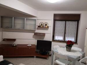 a living room with a table and a television at CASETTA DI FEM in Sabbionara