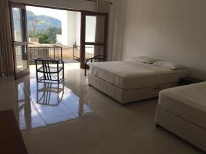 una camera da letto con due letti, un tavolo e delle sedie di The View at Glenloch - Home Stay a Tawalantenna