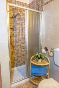 a bathroom with a shower and a table with flowers on it at Casa Al Bosco in SantʼEllero