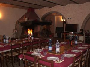 a dining room with a long table and a fireplace at Agriturismo SANTA BARBARA in San Miniato