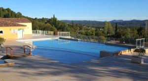 a large swimming pool in front of a house at Appartement dans Residence – Le Domaine de Camiole in Callian