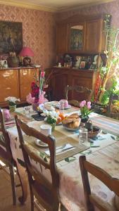 a dining room with a table with food on it at Chambre de la baronne de Rochegrosse in Saint-Maurice-en-Gourgois