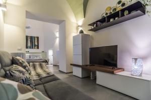 uma sala de estar com um sofá e uma televisão de ecrã plano em Elle Suite em Lecce