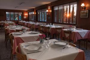 a dining room with tables and chairs with white tablecloths at Baita Carla in Brunate