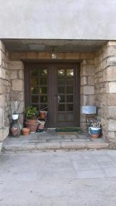 a front door of a house with potted plants at Chambre de la baronne de Rochegrosse in Saint-Maurice-en-Gourgois