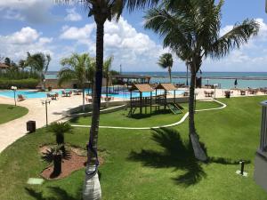 vista para a piscina do resort com palmeiras em Marupiara Suites Flats em Porto de Galinhas