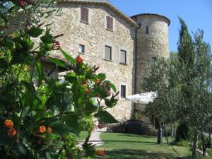 古比奧的住宿－Agriturismo Castello Di San Vittorino，一座大型石头建筑,上面有一座塔