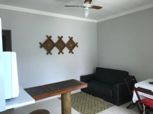 sala de estar con sofá negro y mesa en Residencial Camburyá en Camburi