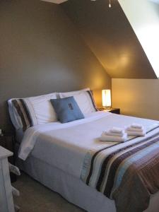 ein Schlafzimmer mit einem großen Bett mit Handtüchern darauf in der Unterkunft Le Goéland in Tadoussac