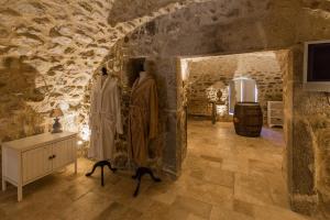 Habitación con pared de piedra y perchas. en Les Hiboux du Domaine du Moulin, en Étables