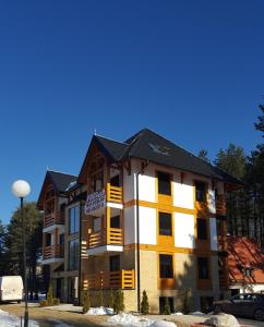 a apartment building with yellow and white at Central point Zlatibor in Zlatibor
