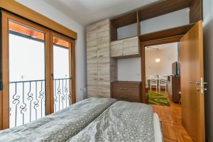 a bedroom with a bed and a large window at Central point Zlatibor in Zlatibor