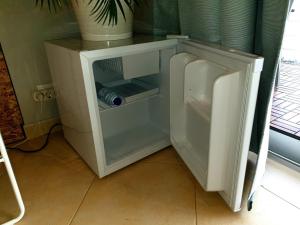 a small white refrigerator with a water bottle in it at SunHouse Room in Albufeira