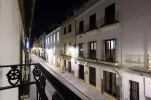 an empty city street at night with white buildings at La Terraza de Alfaros & Parking Gratuito in Córdoba
