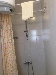 a bathroom with a shower with a towel hanging on the wall at Mini-Studio With Free Private Beach in Hurghada