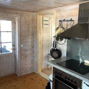 a kitchen with a stove and a counter top at Himalayan cabin Inkoo in Inkoo