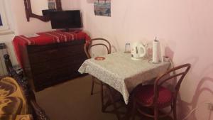 a small table with chairs and a table with a red suitcase at Dubrovnik Sea View Apartment in Dubrovnik