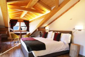 ein Schlafzimmer mit einem großen Bett in einem Zimmer mit Holzdecken in der Unterkunft Le Petit Lievre in Aosta