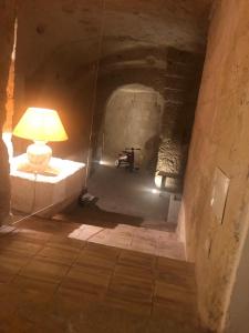 um quarto com um candeeiro sobre uma mesa num túnel em Gli Ipogei nel cuore di matera em Matera