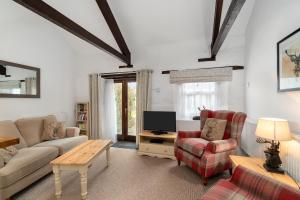 a living room with a couch and a tv at Rose Cottage in Paignton