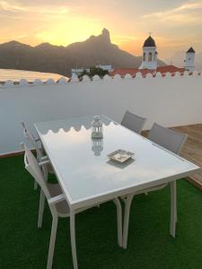 una mesa y sillas blancas con vistas al océano en Casa Guayarmina, en Tejeda