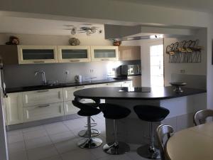 uma cozinha com um balcão preto e bancos em AU BONHEUR em Idron