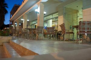 a group of chairs and tables on a patio at Tylos Beach Hotel in Kato Pyrgos