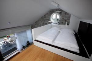 a large white bed in a room with a window at Pálavské Apartmány in Pavlov