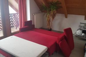a red and white table and chair in a room at Ruhige Wohnung bei München, Fürstenfeldbruck, Dachau in Oberschweinbach