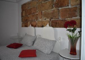 a living room with a couch and a brick wall at Alma Nua in Terrasini