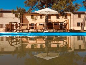 uma piscina com guarda-sol e cadeiras e uma casa em Villa Brettino- Pesaro mare e cultura - intera struttura con piscina em Fano