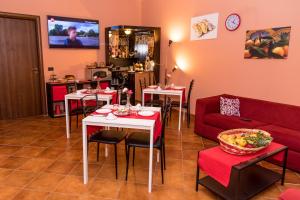 a living room with tables and a red couch at Gli Ulivi Dell'Etna in Linera