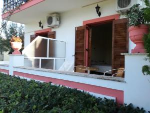 Cette maison blanche aux accents rouges dispose d'une terrasse. dans l'établissement Tony studio & apartments, à Laganas