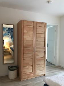 エッカーンフェルデにあるSEASIDE APARTMENTS - BEACHHOUSE BLUEの鏡付きのベッドルーム内の木製キャビネット