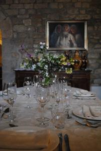 stół z kieliszkami do wina i kwiatami w obiekcie Agriturismo Castello Di San Vittorino w mieście Gubbio