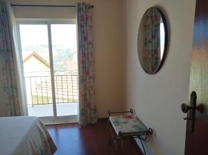 una camera con letto e specchio e un balcone di Casa D. Antónia a Gouvães