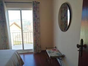 a bedroom with a bed and a mirror and a balcony at Casa D. Antónia in Gouvães