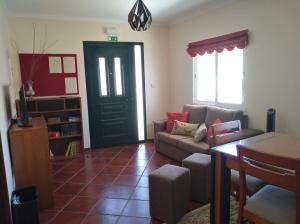 uma sala de estar com um sofá e uma porta em Casa D. Antónia em Gouvães