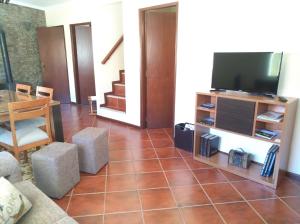 a living room with a television and a tiled floor at Casa D. Antónia in Gouvães