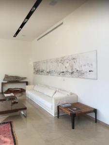 salon z białą kanapą i stołem w obiekcie Villa Alice Caesarea w mieście Cezarea