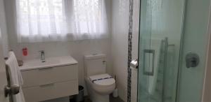 a bathroom with a toilet and a glass shower at Rose Apartments Unit 6 Central Rotorua-Accommodation & Spa in Rotorua +10 photos