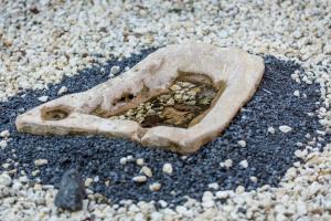 a piece of rock sitting on the sand at Gli Ulivi Dell'Etna in Linera