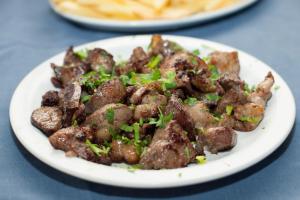 a plate of food with meat on a table at Tylos Beach Hotel in Kato Pyrgos