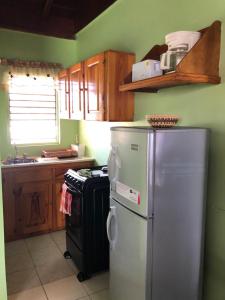 a kitchen with a refrigerator and a stove at Seascape Apartments in Negril