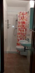 y baño con ducha, lavabo y bañera. en Casa Deledda, en La Caletta