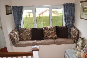 a living room with a couch in front of a window at Sunnycroft in Sutton on Sea