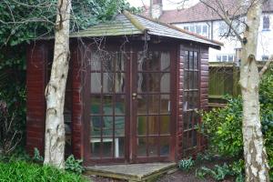 a garden shed with a large glass door at Sunnycroft in Sutton on Sea