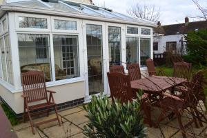 a screened in porch with a table and chairs at Sunnycroft in Sutton on Sea