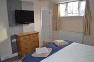 a bedroom with a bed and a tv on the wall at Sunnycroft in Sutton on Sea