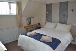 a bedroom with a bed with two towels on it at Sunnycroft in Sutton on Sea